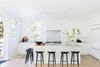 Modern home with Ceiling Lighting, Light Hardwood Floor, and Pendant Lighting. Kitchen with white panel cabinetry, marble counters and black bar stools. Photo 12 of Sea Cliff Preppy Contemporary