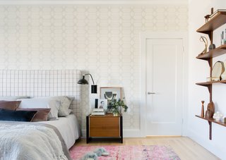 Master bedroom with patterned headboard and wallpaper.