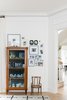 Modern home with Living Room, Light Hardwood Floor, and Storage. Heirloom curio cabinet and family photo gallery wall. Photo 4 of Sea Cliff Preppy Contemporary