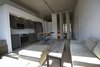 Looking into the main space from the front windows. Custom, floor-to-ceiling doors in a track can rotate or stack neatly against the wall. LED lights in the kitchen reflect off of the high gloss millwork. Photo of Silver Lining Loft modern home