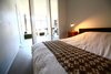 Inside bedroom looking through the monumental-scale doors that rotate closed or glide in their track to against the wall. Photo 5 of Silver Lining Loft modern home