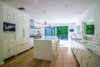 A spacious chef's kitchen features Calacatta marble countertops, Wolf and Miele appliances, a large eat-in island, and sliding walls of glass to an expansive rear deck for entertaining. Photo 3 of Nichols Canyon modern home