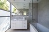 The home was thoughtfully designed to take full advantage of the property's idyllic surroundings. A serene guest bathroom features a frosted wall of glass and clerestory window, inspiring a gracious play on light and shadow. Photo 4 of Nichols Canyon modern home