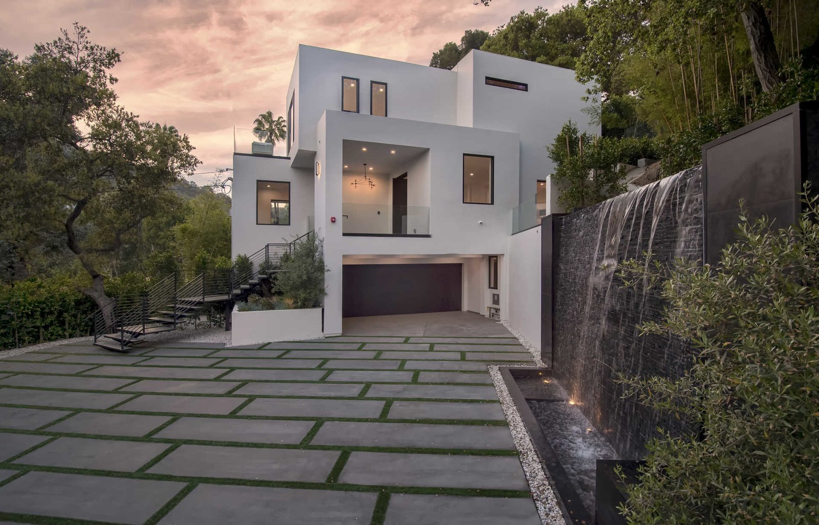 A contemporary fountain wall beckons guests inside the residence.