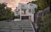 A contemporary fountain wall beckons guests inside the residence. Photo of Cherokee Contemporary modern home