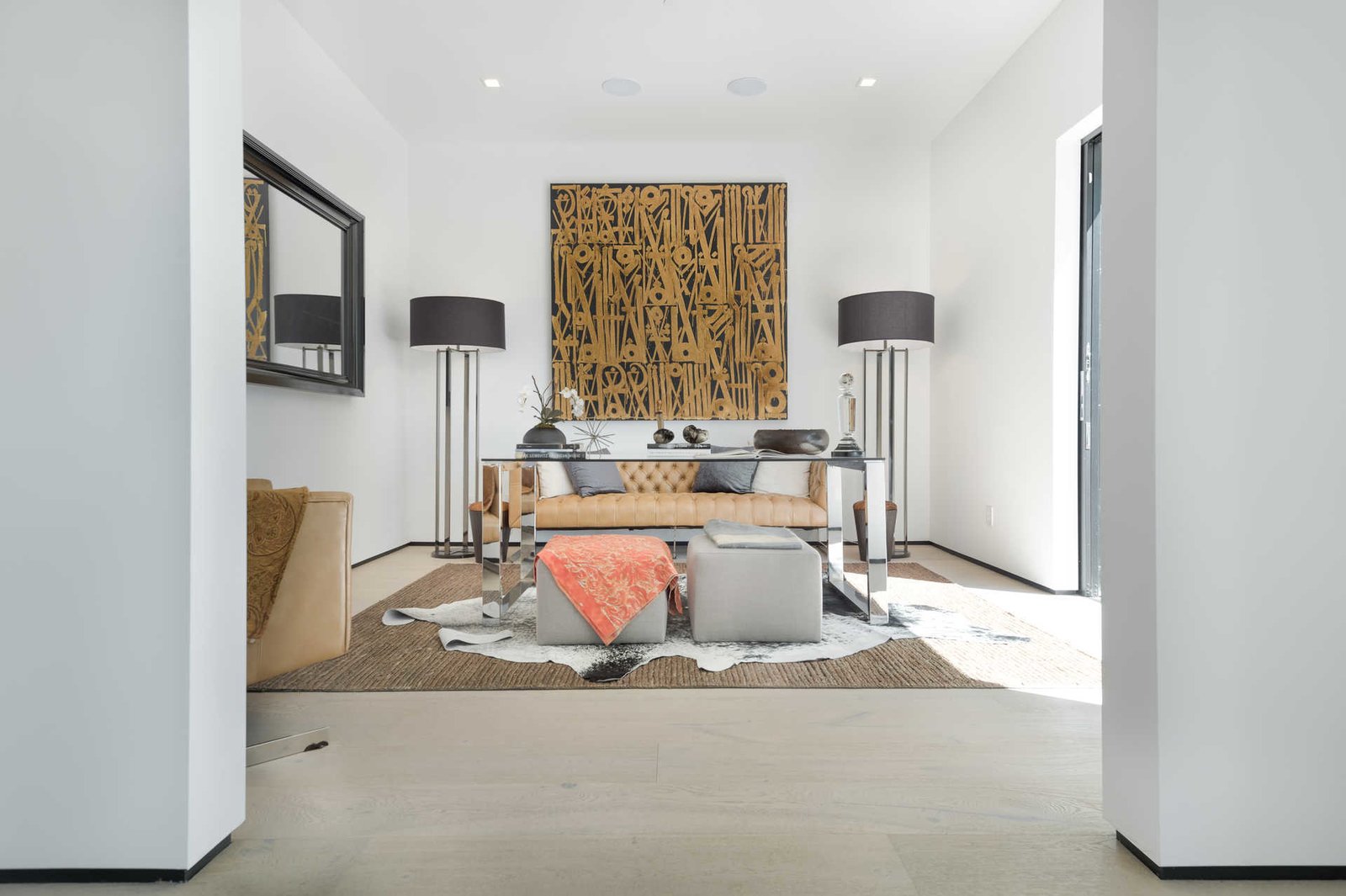 An elegant study off the main entry features a tranquil outdoor garden and faces an open living area with fireplace.