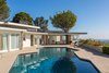 An incredible pool is set against spectacular city views with glass sliders evoking a seamless indoor-outdoor connection. Photo 8 of Hillcrest Road modern home