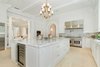 The magnificent chef’s kitchen showcases custom cabinetry, stacked Wolf appliances, and a large eat-in island, with doors off the breakfast area offering a gracious flow to the gardens. Photo 4 of Benedict Canyon Villa modern home
