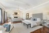 The 1700-square-foot master bedroom showcases inlaid walnut floors, a large fireplace, and French doors to a private terrace. Photo 5 of Benedict Canyon Villa modern home