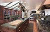 An expansive chef's kitchen with a farmhouse sink and large center island Photo 7 of Malibu Colony Road modern home