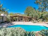 The home as viewed from the backyard, now and then. Mature landscaping and new dining areas elevate the outdoor spaces. Photo of Midcentury Post and Beam In Fryman Canyon modern home