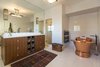 Modern home with Back Yard, Large Pools, Tubs, Shower, Wood Fences, Wall, Large Patio, Porch, Deck, Landscape Lighting, Tile Patio, Porch, Deck, Wall Lighting, Sofa, Chair, Ottomans, Dark Hardwood Floor, Wood Burning Fireplace, Ceiling Lighting, Table, Interior, Swing Door Type, Bed, Medium Hardwood Floor, Shelves, and Bath Room. An elegant master suite with a standalone copper soaking tub adds contemporary appeal to the historic residence. Photo 7 of A Santa Monica Beach House Built for Norma Talmadge