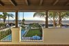 Modern home with Back Yard, Landscape Lighting, Large Patio, Porch, Deck, Tile Patio, Porch, Deck, Wood Fences, Wall, Large Pools, Tubs, Shower, Chair, Sofa, Wall Lighting, Dark Hardwood Floor, Ottomans, Wood Burning Fireplace, Ceiling Lighting, Table, Interior, Bed, Swing Door Type, Shelves, Medium Hardwood Floor, and Freestanding Tub. An ocean-facing terrace overlooks the pool below and stunning views of the ocean and coast beyond. Photo 8 of A Santa Monica Beach House Built for Norma Talmadge