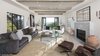 Modern home with Living Room, Chair, Sofa, Coffee Tables, Recessed Lighting, Wall Lighting, Light Hardwood Floor, Gas Burning Fireplace, and Wood Burning Fireplace. A light-filled living room has been exquisitely reimagined with contemporary appeal. Sliding pocket doors open to a balcony revealing sweeping city views. Photo of A 1930s Spanish Colonial in Los Feliz Reimagined for the 21st Century
