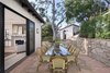 Modern home with Outdoor, Side Yard, Trees, Gardens, Walkways, Raised Planters, and Stone Patio, Porch, Deck. An outdoor dining patio off the living room embraces the quintessential California lifestyle. Photo 4 of A 1930s Spanish Colonial in Los Feliz Reimagined for the 21st Century