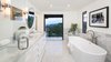 Modern home with Bath Room, Marble Counter, Enclosed Shower, Drop In Sink, Recessed Lighting, Marble Wall, Wall Lighting, Freestanding Tub, and One Piece Toilet. A soaking tub in the master bathroom, with doors to the observation terrace. Photo 12 of A 1930s Spanish Colonial in Los Feliz Reimagined for the 21st Century