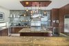 Modern home with Kitchen, Granite Counter, Stone Tile Backsplashe, and Pendant Lighting. The gourmet kitchen with large, center prep island, stone backsplash and pendant lighting. Photo 4 of A Contemporary Makeover Transforms Oceanfront Villa Serena