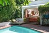 Modern home with Outdoor, Garden, Trees, Back Yard, Grass, Walkways, Large Pools, Tubs, Shower, Gardens, Flowers, Swimming Pools, Tubs, Shower, Stone Patio, Porch, Deck, and Wood Fences, Wall. Sun-swept interiors flow graciously to verdant outdoor areas—and a generous swimming pool—for a decidedly bohemian living experience. Photo of A Charming 1920s Spanish in West Hollywood's Storied Norma Triangle