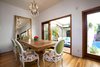 Modern home with Dining Room, Chair, Ceiling Lighting, Table, Accent Lighting, and Medium Hardwood Floor. The dining area flows seamlessly to an outdoor seating area through folding pocket doors, encouraging al fresco entertaining. Photo 5 of A Charming 1920s Spanish in West Hollywood's Storied Norma Triangle