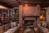 Modern home with Living Room, Sofa, Ceiling Lighting, and Wood Burning Fireplace. A dramatic brick fireplace, exposed wood beams, and built-in bookshelves with a vintage rolling library ladder add period charm to the residence. Photo 2 of Authentic 1930s Country English Compound in Fryman Canyon