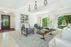 Modern home with Living Room, Chair, Ceiling Lighting, and Light Hardwood Floor. Beautiful white oak hardwood floors complement original Spanish tiles and bold, dark wood doors, while wrought iron railings and graceful archways lend character and charm to the interiors. Photo 2 of A Reimagined Spanish Hideaway in the Hollywood Hills