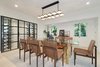 Modern home with Dining Room, Table, Ceiling Lighting, Light Hardwood Floor, and Accent Lighting. A contemporary dining room is crowned by a glass-enclosed, floating wine display. Photo 3 of A Reimagined Spanish Hideaway in the Hollywood Hills