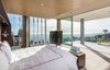 Modern home with Bedroom, Ceiling Lighting, Bed, Night Stands, Light Hardwood Floor, Bench, and Accent Lighting. A glass-enclosed master suite is equipped with automatic shades and sliding glass doors to a large terrace that appears to float weightless over the lights of Los Angeles. Photo 7 of An Architectural Gem on the Bird Streets of Los Angeles