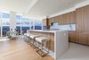 Modern home with Kitchen. The seamless, gourmet kitchen boasts Caesarstone countertops and backsplashes, custom wood cabinetry, Miele and Bosch appliances and wine fridge. Photo 2 of Two-Story Penthouses Atop Metropolis Bring All of Los Angeles Into View