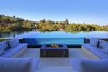 The cozy fire pit lounge overlooks the infinity-edge pool. Photo 10 of An Architectural Masterpiece Shines Above the Bel Air Golf Course modern home