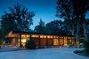 Modern home with Exterior, Metal Siding Material, Flat RoofLine, Mid-Century Building Type, Wood Siding Material, House Building Type, and Glass Siding Material. The mostly transparent street elevation gives a glimpse into the home, while the fireplace feature wall provides privacy to the rear spaces. The structural grid is expressed at the exterior with black cladding wrapped onto the steel frame between the wall panels. A continuous band of clerestory windows wraps the entire home and gives the roof a floating feel. Photo 2 of Pleasant Street Residence