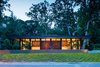 Modern home with Exterior, House Building Type, Flat RoofLine, Wood Siding Material, Mid-Century Building Type, Metal Siding Material, and Glass Siding Material. The mostly transparent street elevation gives a glimpse into the home, while the fireplace feature wall provides privacy to the rear spaces. The structural grid is expressed at the exterior with black cladding wrapped onto the steel frame between the wall panels. A continuous band of clerestory windows wraps the entire home and gives the roof a floating feel. Photo 9 of Pleasant Street Residence