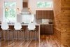 Modern home with Kitchen, Engineered Quartz Counter, and Wood Cabinet. With ample natural light and a hidden pantry, this kitchen serves as well as it entertains. Walnut millwork is accented by clean white work surfaces and stainless steel backsplash. Photo 7 of Dogwood Residence