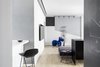 Modern home with Kitchen, Granite Counter, Marble Counter, White Cabinet, Open Cabinet, Light Hardwood Floor, Concrete Backsplashe, and Ceiling Lighting. View from the entrance to the Living Room Photo 7 of A|A Duplex