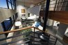 Modern home with Living Room, Lamps, Sectional, Coffee Tables, Chair, Floor Lighting, Recessed Lighting, Concrete Floor, and Hanging Fireplace. two story volume - looking down at living room and office Photo 17 of Governors Plaza