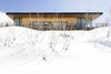 Modern home with Exterior, House Building Type, Metal Roof Material, Wood Siding Material, Flat RoofLine, Shed RoofLine, and Cabin Building Type. Snow buries scrub oak trees in front of the home's west elevation. Photo 3 of Red Hawk