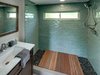 Bathroom with sea green tiles and Abaco flooring Photo 3 of Amplified Tiny House modern home