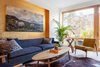 Modern home with Living Room, Sofa, Chair, End Tables, Coffee Tables, Ceiling Lighting, Light Hardwood Floor, Gas Burning Fireplace, and Rug Floor. Living room with gold-leafed niche Photo 4 of Ritchie Rowhouse
