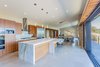 Modern home with Kitchen, Wood Cabinet, Limestone Floor, Marble Counter, Refrigerator, Wall Oven, Cooktops, Range Hood, Stone Slab Backsplashe, Ceiling Lighting, Pendant Lighting, and Undermount Sink. Daniel J Strening carved out some outdoor space under the roof to extend the living area and blur the boundaries between indoors and outdoors. Photo 10 of Healdsburg Home