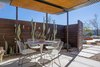 Modern home with Outdoor, Side Yard, Trees, Garden, Desert, Walkways, Gardens, Small Patio, Porch, Deck, Wood Patio, Porch, Deck, Decomposed Granite Patio, Porch, Deck, Concrete Patio, Porch, Deck, Metal Patio, Porch, Deck, Horizontal Fences, Wall, Wood Fences, Wall, and Metal Fences, Wall. Enclosed inner patio showing corrugated shade structures with dropped wood panels that provide cool shade. Photo 2 of Modern Jewel in the Desert