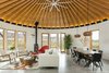 Modern home with Front Yard, Shrubs, Grass, and Living Room. The largest of the three yurt structures houses the living and dining rooms and provides panoramic views. A geometric hide rug by Dedalo Rugs ties in pops of red from Eero Saarinen's Womb Chair, and pale blue from the Room and Board cushions on the sofa. The homeowners sourced the Oggetti Showtime coffee table from Wayfair. A pair of Kichler pendants define the dining area. Photo 3 of Yurt-Inspired Home on the Range