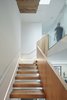 Modern home with Staircase, Wood Tread, Glass Railing, and Wood Railing. Central Stair, looking up toward upper sleeping level. Photo 20 of Noe Valley House