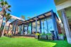 Modern home with Exterior, House Building Type, Beach House Building Type, Prefab Building Type, Wood Siding Material, Glass Siding Material, and Flat RoofLine. Complete with a bronze anodized frame, 10-foot ceilings, and an outdoor shower, this oceanfront home in Malibu, California takes full advantage of its idyllic location. Photo of The Surfer's Dream