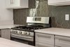 Modern home with Kitchen, Engineered Quartz Counter, White Cabinet, Wood Cabinet, Glass Tile Backsplashe, and Range. Quartz countertops and glass hexagon tiles Photo 9 of Briarwood Place