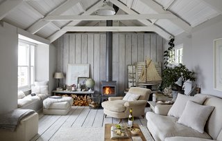 The Oyster Catcher is a 17th-century net loft on the harbor's edge in the town of Mousehole. It was given new life by interior designer Paul Massey with pendant lights, Siberian goose down, and soft, warm linens. 