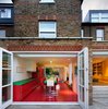 Modern home with Kitchen, Wall Oven, Range Hood, Range, Ceiling Lighting, Recessed Lighting, and Colorful Cabinet. London architecture studio AMA remodeled this home in an old Edwardian building with bold Bauhaus colors, and transformed the kitchen into an audacious red and green space with glossy vermillion floors. Photo of Chevron House