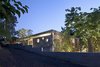 Modern home with Trees, Exterior, Concrete Siding Material, and House Building Type. This home took inspiration from the brutalist buildings found in its Tel Aviv neighborhood. The home is comprised of two concrete squares stacked on top of each other, with a skylight running along the entire length of the stairwell and flooding the home with sunshine. Sections of the silicate-brick walls have circular holes cut out from them in order to connect the various rooms visually. Photo 13 of House of an Architect