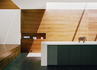 This San Francisco renovation by architect Cary Bernstein is designed with a streamlined built-in cabinet system with built-in speakers, niches for artwork, and drawers tucked under the entryway mezzanine.