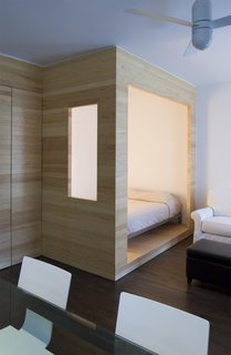 Framework Architecture created a partially enclosed sleeping nook in this tiny Brooklyn studio apartment, which snuggly fits a full-sized bed.