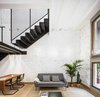 Modern home with Living Room, Table, Chair, Sofa, Coffee Tables, Wall Lighting, and Rug Floor. To retain and emphasize the traditional architecture of the building, the architects used natural terra-cotta for the floors, and stripped the paint from the walls to expose the beautiful textures and imperfections of the original brickwork. Photo 13 of La Diana