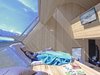 Modern home with Living Room, Wall Lighting, Bench, and Light Hardwood Floor. Part modern art sculpture, part cozy cabin that connects with its natural surroundings, Ufogel is an out-of-this-world vacation home that celebrates bold, convention-defying architecture. Photo 10 of Ufogel